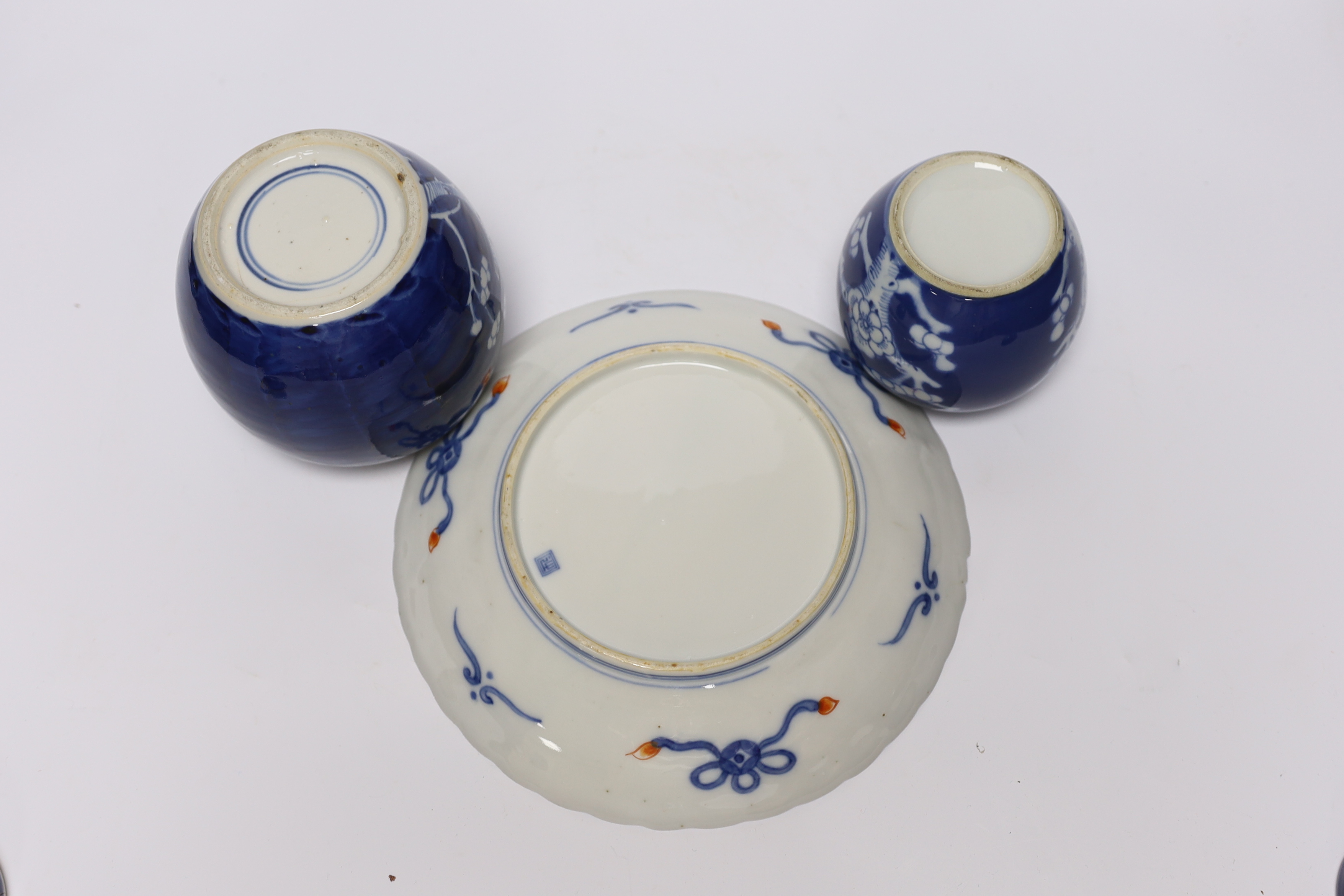 An early 20th century Chinese blue and white vase and cover, pair of 19th century Chinese famille rose dishes, four prunus jars, two covers, a Japanese Meiji period Imari dish and a small satsuma pot, some damage, talles